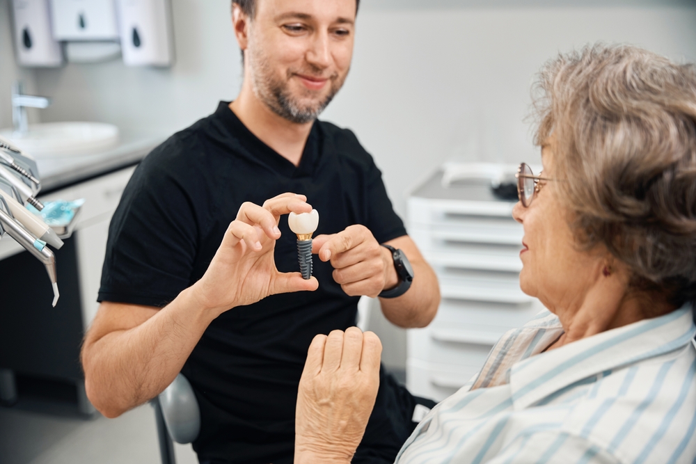 Dentist explaining tooth replacement options with a model