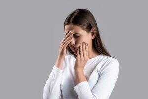 Woman holding her cheek with tooth pain